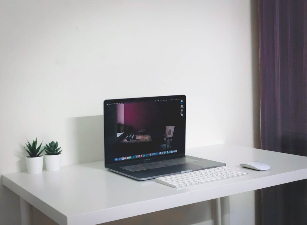 Minimalist desk setup with laptop notebook and plant